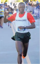  ??  ?? Solomon Kandie, who has called Albuquerqu­e home for a decade, reacts after winning his fifth Duke City Marathon on Sunday. He hopes to compete in Boston next year.