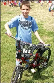  ?? Photo by Randy Moll ?? C.J. Bolinger, 9, was the proud winner of a new bicycle at Gentry’s Easter egg hunt on Saturday.