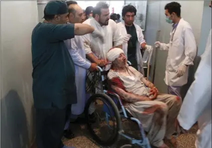  ?? AP PHOTO/HAMED SARFARAZI ?? Relatives assist a wounded man in a hospital after a suicide attack on a mosque in Herat, Afghanista­n on Tuesday. An Afghan hospital official says an explosion inside a minority Shiite mosque in western Herat, on the border with Iran, has killed at...