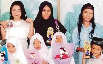  ??  ?? GAMBAR kenangan Siti Halaidah (dua dari kanan) bersama ibunya, Siti Sarta (baris belakang tengah) selepas majlis graduasi tadika tahun lalu.