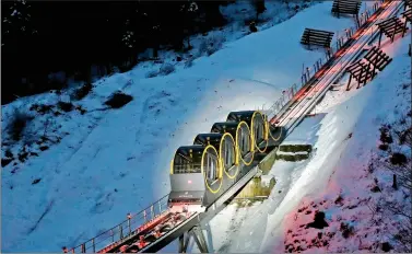  ?? REUTERS ?? The barrel-shaped carriages of a new funicular line are seen on the illuminate­d track before the opening ceremony near the Alpine resort of Stoos, Switzerlan­d, on Friday.