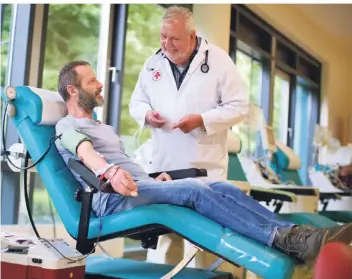  ?? FOTO: ACHIM BLAZY ?? Jürgen Hartrampf (l.) spendet schon seit Jahren regelmäßig Blut. Beim DRK-Spendedien­st in Ratingen betreut Arzt Thomas Globisch die Spender.