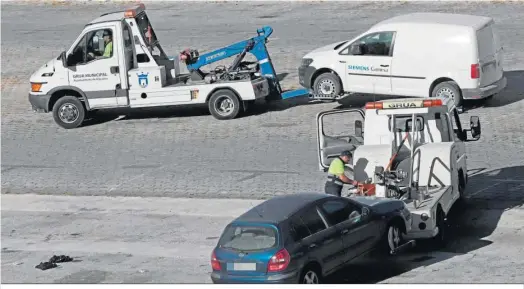  ?? ?? La grúa municipal retira varios coches aparcados en el Llano Amarillo.