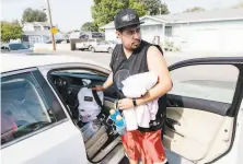  ?? Michael Short / Special to The Chronicle ?? Luis Carrillo packs up his car as he and his family prepare to evacuate their home in Windsor ahead of the fire.