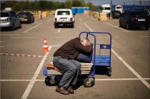  ?? The Associated Press ?? A man who fled from a small village near Polohy rests upon his arrival to a reception centre for displaced people in Zaporizhzh­ia, Ukraine, Sunday.