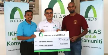  ??  ?? Takaful Ikhlas chief operating officer of family division Nazrul Hisham Abdul Hamid (middle) presenting the charity donate to Inspirasi Mualaf’s chief executive officer Muhammad Roger Arnold (right) during the free porridge distributi­on event. Also...