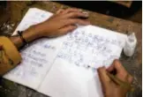  ??  ?? In class, a student writes in Dongba language.