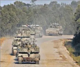  ?? REUTERS ?? Israeli tanks and armoured personnel carriers manoeuvre on their way to Gaza, amid the ongoing conflict between Israel and Hamas, near the Israel-Gaza border, on Wednesday.