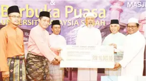  ??  ?? KAMARUDIN (dua kiri) menerima sumbangan zakat bagi pihak UMS daripada wakil Pusat Zakat Sabah sambil diperhatik­an Juhar (tengah), Shafie (tiga kiri), Muhamad (kiri) dan Yusof (dua kanan).