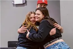  ?? ?? Shaeli Gravell, left, hugs her sister, Jaedyn Gravell, as Riley Zebrowski hugs them both during Wednesday’s ceremony.