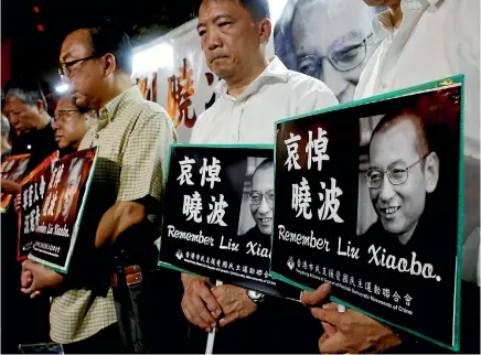  ?? PHOTO: REUTERS ?? Pro-democracy activists mourn the death of Chinese Nobel peace laureate Liu Xiaobo, outside China’s Liaison Office in Hong Kong yesterday.