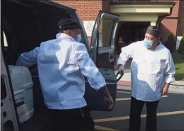  ?? H John Voorhees III / Hearst Connecticu­t Media ?? Chef Blythe Roberts, right, and Chef Jay Streck-Weller load some of the 300 meals that will be delivered by the senior center on Wednesday morning.