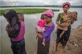  ?? — AP ?? Rohingya Muslim women, who crossed over from Myanmar into Bangladesh, stand holding their sick children after Bangladesh border guard soldiers refused to let them journey towards a hospital and turned them back towards the zero line border in Palong...