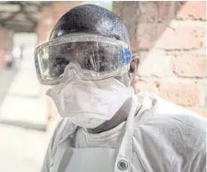  ??  ?? HERE WE GO AGAIN: A health worker wears protective clothing outside an isolation ward to diagnose and treat suspected Ebola patients, at Bikoro Hospital in Bikoro.