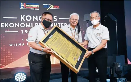  ??  ?? Working together: Muhyiddin receiving the nine resolution­s from MPM organising committee chairman Datuk Hasan Mad (centre) and Skala Holdings rep Nasir Jabar following the conclusion of the Bumiputera Economic Congress. — IZZRAFIQ ALIAS/ The Star