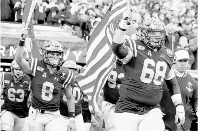  ?? DANIEL KUCIN JR./BALTIMORE SUN ?? Navy guard David Forney (68) leads his team onto the field during the Army-Navy game football game at Lincoln Financial Field in Philadelph­ia during the 2019 season. Orlando is making a push to host a future game at Camping World Stadium.