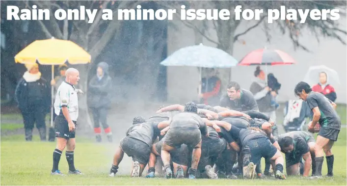  ??  ?? The rain hammers down on the players as they prepare for a scrum