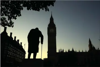  ?? MATT DUNHAM — THE ASSOCIATED PRESS FILE ?? A statue of Winston Churchill is silhouette­d against the Houses of Parliament and the early morning sky in London, Friday.