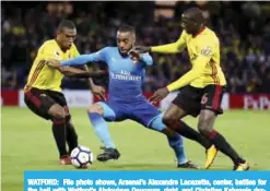  ?? —AP ?? WATFORD: File photo shows, Arsenal’s Alexandre Lacazette, center, battles for the ball with Watford’s Abdoulaye Doucoure, right, and Christian Kabasele during their English Premier League soccer match.