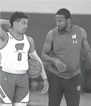  ?? RICK WOOD / MILWAUKEE JOURNAL SENTINEL ?? UW assistant coach Alando Tucker talks with guard D’Mitrik Trice during a practice.