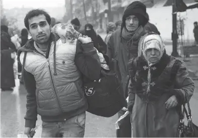  ?? KARAM AL-MASRI / AFP / GETTY IMAGES ?? Syrians leave a rebel-held area of Aleppo on Tuesday during an operation by Syrian government forces to retake the embattled city. UN chief Ban Ki-moon expressed alarm over reports of atrocities against civilians.