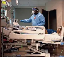  ??  ?? Christophe­r Yates, certified respirator­y therapy technician works with a patient inside Methodist University Hospital's COVID unit on Friday, Aug. 21, 2020.