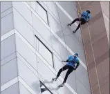 ?? ?? Two friends, John Guzzi, left, and Nadeen Hussain, both 28, from Milford, rappel from the top of the People’s United Bank building.