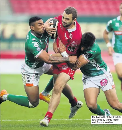  ??  ?? Paul Asquith of the Scarlets is tackled by Monty Ioane and Tommaso Allan.