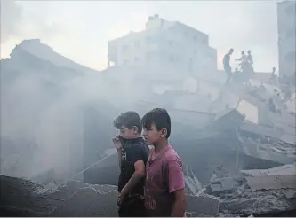  ?? KHALIL HAMRA THE ASSOCIATED PRESS ?? Palestinia­ns inspect the damaged building of Said al-Mis'hal cultural centre after it was bombed by an Israeli airstrike in Gaza City, Thursday, Aug. 9.