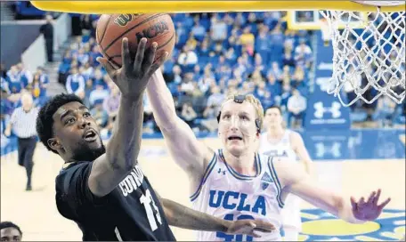  ?? Mark J. Terrill Associated Press ?? UCLA CENTER Thomas Welsh, trying to stop Colorado guard Namon Wright from scoring, made nine of 10 shots against the Buffaloes.