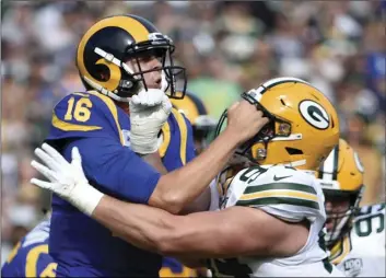  ??  ?? Los Angeles Rams quarterbac­k Jared Goff (left) is hit by Green Bay Packers defensive end Dean Lowry after throwing a pass during the first half of an NFL football game, on Sunday, in Los Angeles. AP PHOTO/DENIS POROY