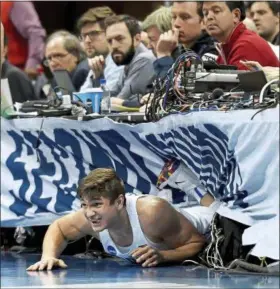  ?? MATT FREED — POST-GAZETTE VIA AP ?? Duke’s Grayson Allen ends up under the media row after diving for a loose ball against Rhode Island in the first half of the second-round game of the NCAA tournament March 17 in Pittsburgh.
