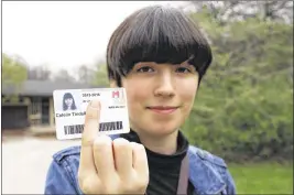  ?? CARRIE ANTLFINGER / AP ?? Catelin Tindall holds her expired student ID from the Milwaukee Institute of Art and Design at Cannon Park in front of the building where she tried to vote during the November 2016 presidenti­al election.