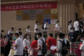  ?? ASSOCIATED PRESS FILE PHOTO ?? Students line up to enter a school for the first day of China’s national college entrance examinatio­ns, known as the gaokao, in Beijing, June 7, 2022.