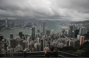  ?? — AP ?? Portfolio outflows:
A visitor sets up his camera at the Victoria Peak area in Hong Kong. Although the city has a Us$466bil (RM2 trillion) foreign-reserves stockpile, signs of financial stress are building.