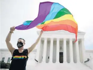  ?? CHIP SOMODEVILL­A/GETTY ?? Joseph Fons holds a pride flag in front of the U.S. Supreme Court building after the court ruled Monday that LGBTQ people cannot be discipline­d or fired based on their sexual orientatio­n.