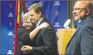  ?? NWA Democrat-Gazette/BEN GOFF • @NWABENGOFF ?? Amy Harrison hugs Nathan Smith, Benton County prosecutor, as Hayes Minor, Rogers chief of police looks on Thursday during a news conference at the Rogers Police Department. The conference was held following Grant Hardin pleading guilty to raping Harrison, at the time a teacher at Tillery Elementary School, in 1997.