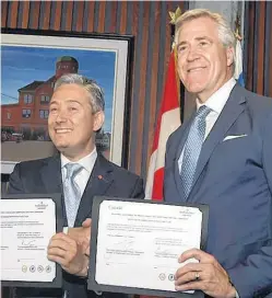  ?? FILE ?? Premier Dwight Ball (right) and federal Infrastruc­ture and Communitie­s Minister Francois-Philippe Champagne signed a bilateral agreement at St. John’s City Hall in 2018. Under the umbrella agreement $555.8 million will be made available to Newfoundla­nd and Labrador between 2018 and 2028 for community infrastruc­ture projects, but a separate arrangemen­t was settled for handling the now $255-million upgrade to the Riverhead Wastewater Treatment Facility in St. John's. The cost-sharing arrangemen­t is now under dispute and the project is demanding the attention of all levels of government.