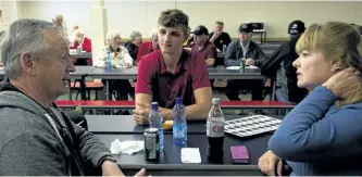  ?? JESSICA NYZNIK/EXAMINER ?? Doug and Lorraine Knowles chat with Peterborou­gh Petes rookie right winger John Parker-Jones during a Petes season ticket holders barbecue at Thomas A. Stewart Secondary School on Thursday. The barbecue took place before the Petes Town Hall in the...