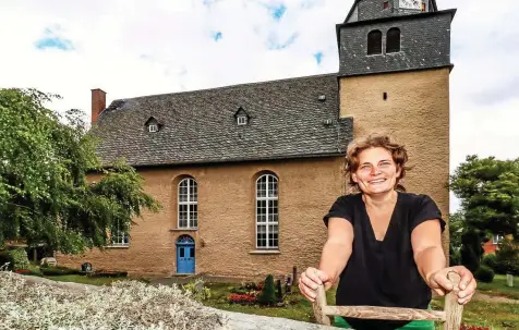  ?? CONNI WINKLER ?? Klaudia Riedel inspiziert ein letztes Mal die Kirchenmau­er in Langenwetz­endorf und schaut nach dem Unkraut, welches noch entfernt werden muss.