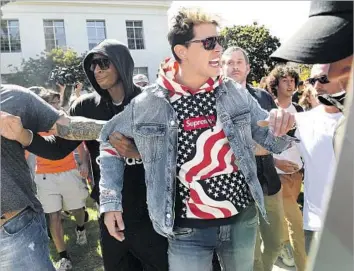  ?? Photograph­s by Wally Skalij Los Angeles Times ?? CONSERVATI­VE provocateu­r Milo Yiannopoul­os is escorted from UC Berkeley’s Sproul Plaza. After months of sometimes violent clashes between the far left and far right, Sunday’s event felt anticlimac­tic.