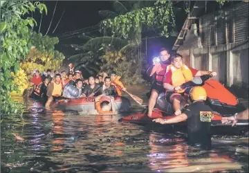  ?? — AFP photo ?? Rescue workers evacuate flood-affected residents in Davao on the southern Philippine island of Mindanao.
