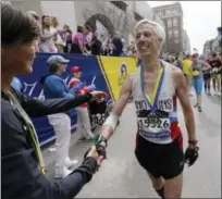  ?? ELISE AMENDOLA — THE ASSOCIATED PRESS ?? Multi-time Boston Marathon winner Uta Pipping, left, congratula­tes Ben Beach, brother of New Haven Register columnist, after he finished running his 50th consecutiv­e Boston Marathon on Monday.