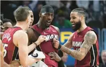  ?? PAULSANCYA/AP ?? Heat center Bam Adebayo, center, celebrates his game-winning shot with Duncan Robinson,left,and Caleb Martin on Sundayin Detroit.