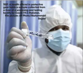  ??  ?? TEST: A health official in protective gear holds a sample collected from a man at a screening and testing facility for Covid-19 in Pakistan.
File picture: AP Photo/muhammad
Sajjad