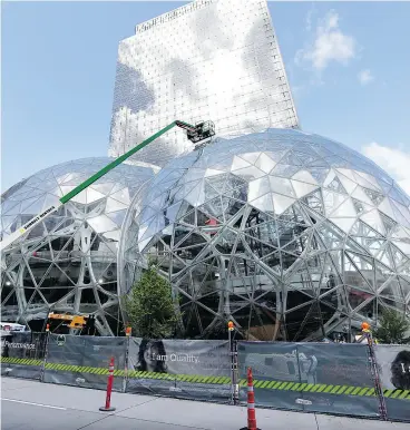  ?? ELAINE THOMPSON / THE ASSOCIATED PRESS FILES ?? Constructi­on continues earlier this year on large, glass- covered domes that are part of an expansion of the Amazon.com campus in downtown Seattle.