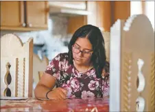  ?? MORGAN TIMMS/Taos News ?? Taos Academy eighth-grader Mariebella Duran responds to letters she’s received Friday (May 8) at her dining room table in Taos.