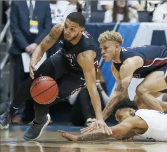  ?? Associated Press ?? Darnell Edge, left, scrambles to come up with a loose ball in Fairleigh Dickinson’s 8276 First Four win against Prairie View A&amp;M Tuesday night in Dayton, Ohio.