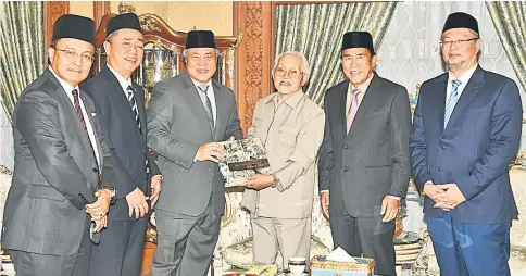  ??  ?? Taib (third right) receives a memento from Awang Tengah. From left are Abdullah, Zaidi, Len, and Wan Lizosman.