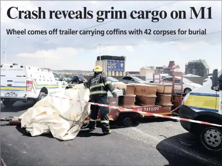  ?? PICTURES: ITUMELENG ENGLISH / ANA ?? CRASH SCENE: The trailer with the coffins of 16 adults and 26 stillborns on the M1 highway yesterday. The bodies were being moved from the Charlotte Maxeke Academic Hospital to the Olifantsvl­ei cemetery in Eldorado Park for burial when one of the...